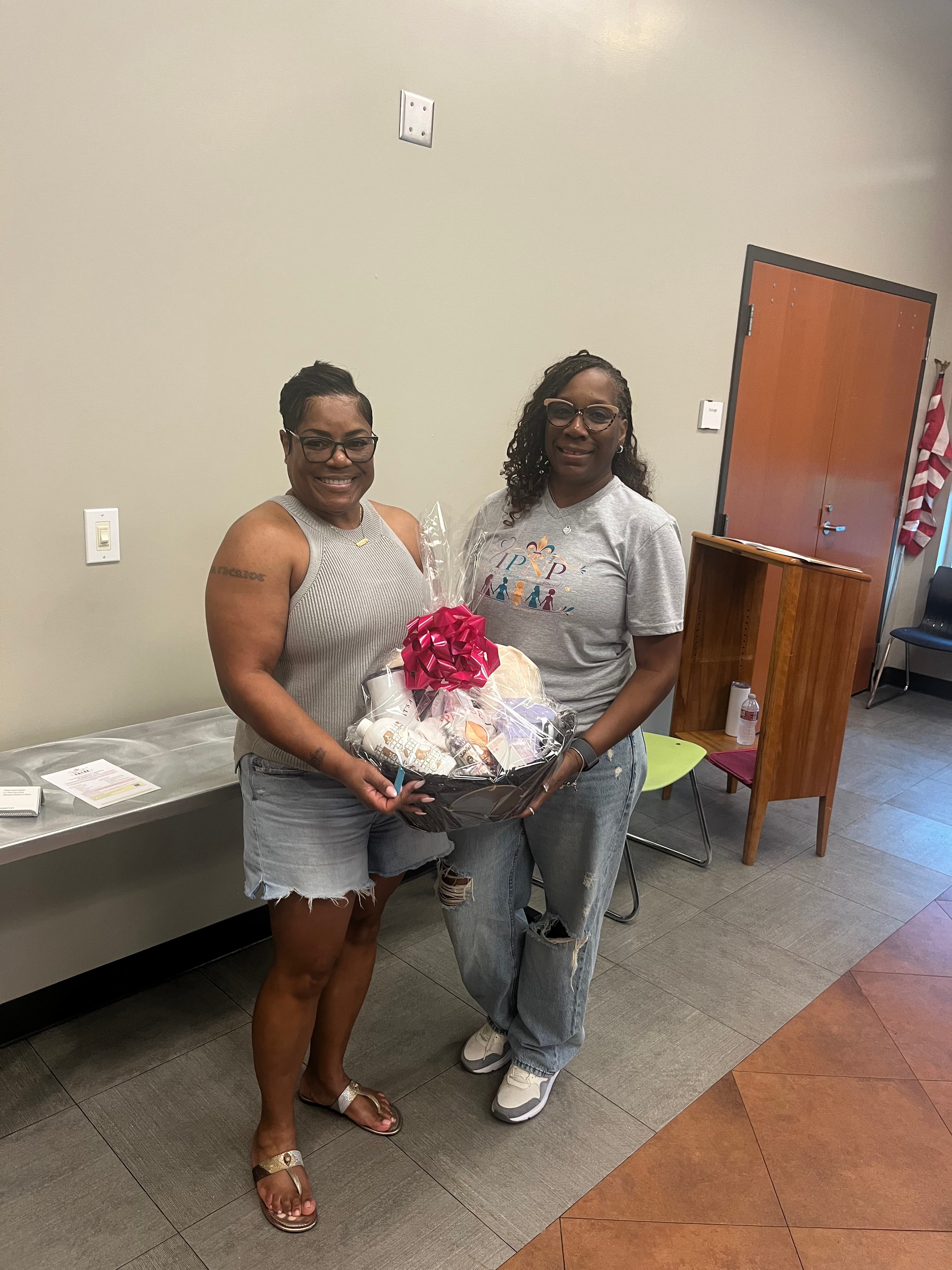 Two women holding the Houma meeting prize gift basket